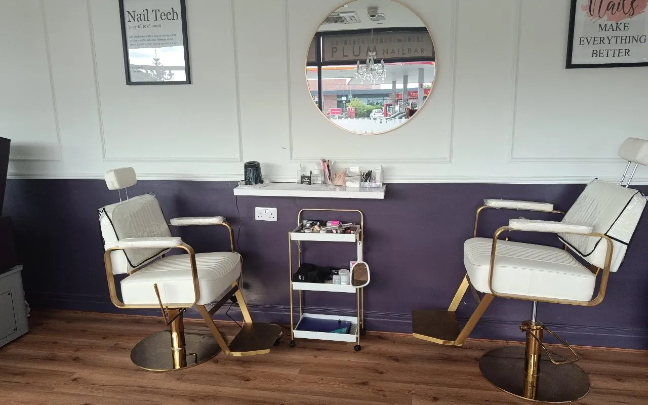 The brow and beauty chairs against the plum wall